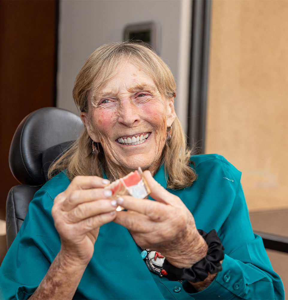 patient holding a full arch dental model within the dental center