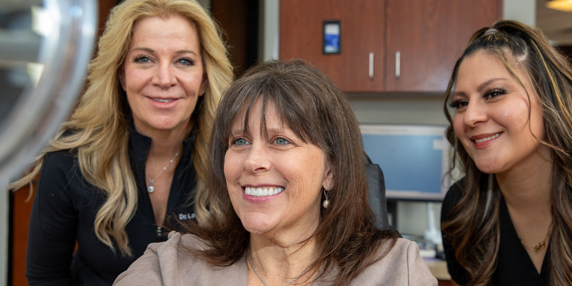 patient and staff member smiling brightly after patient smile procedure