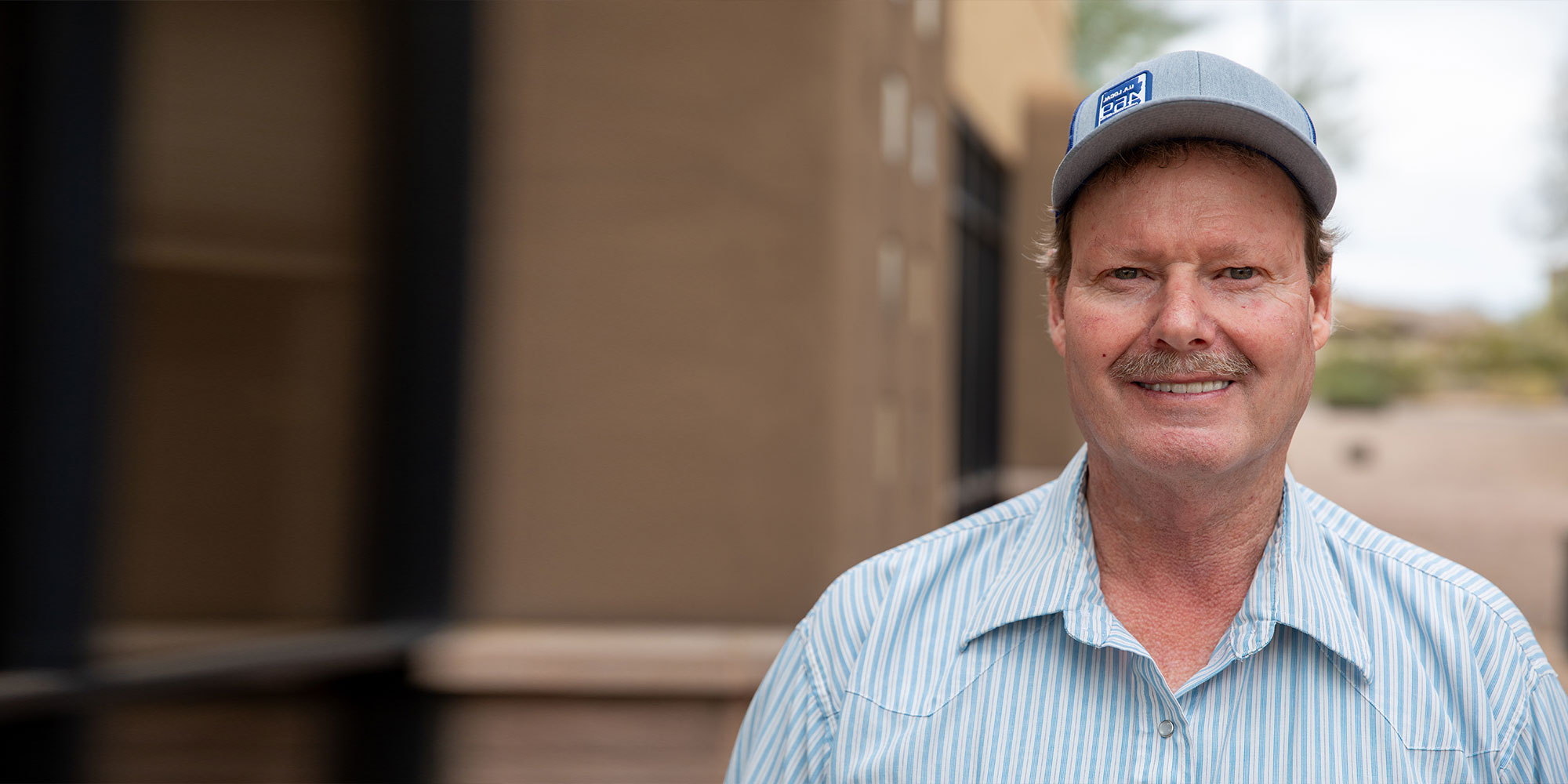 patient smiling brightly outside of the dental center finishing up their dental implant treatment