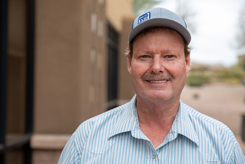 patient smiling brightly outside of the dental center finishing up their dental implant treatment
