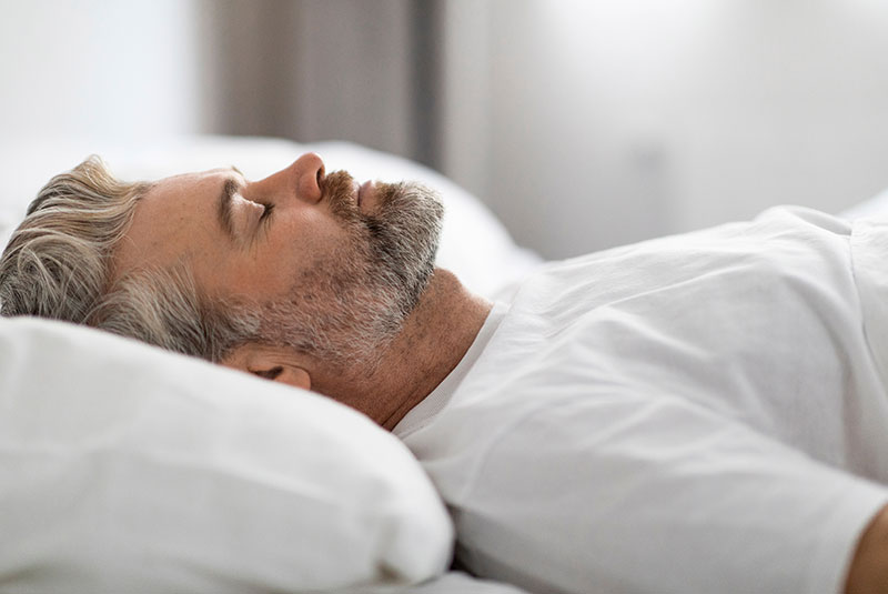 Middle aged man sleeping in bed