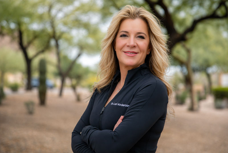 headshot of doctor standing outside and smiling